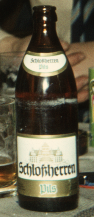 Das Foto einer braunen Halbliter-Bierflasche mit Etikett "Schlossherren Pils". Aufgenommen 1979/80