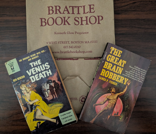 paper bag for the Brattle Book Shop. Two pulp paperback novels on it.

1. The Venus Death by Ben Benson. drawing of a blonde woman in a yellow coat, holding a gun. "She brought desire with her... and murder" ... "A rookie trooper, a gorgeous dame ... and murder"

2. The Great Brain Robbery by James P Fisher. unclothed man, discretely shadowed, reaching towards the sky. red planet behind him. "College student Dennis Sands agreed to go to the weird planet Ikonia. If he had known why he had really been invited, he would have stayed home.