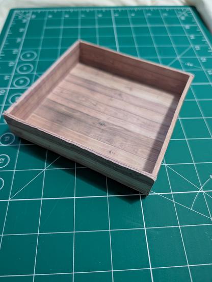 a square tray made of cardboard covered with wood textured paper