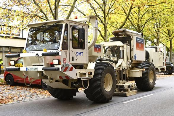 A so-called Vibro Truck. A heavy metal plate is lowered to the ground and a vibration sweep is initiated. The truck itself looks a bit like a heavy lunar rover. At the front a closed cabin for the operator, in the middle the vibration plate and hydraulics, at the back the diesel engine and pumps. Some parts are covered for noise insulation, but most parts are clearly visible and open. Thousands of probes are distributed all over the city that receive these sweeps, allowing to create a detailed 3D map of the underground, showing potential hot water streams that can be used for geothermics. Picture by Robert Haas