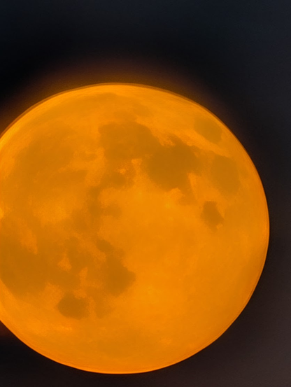 Pretty clear and crisp zoomed in photo of the moon, very orange on a black background.